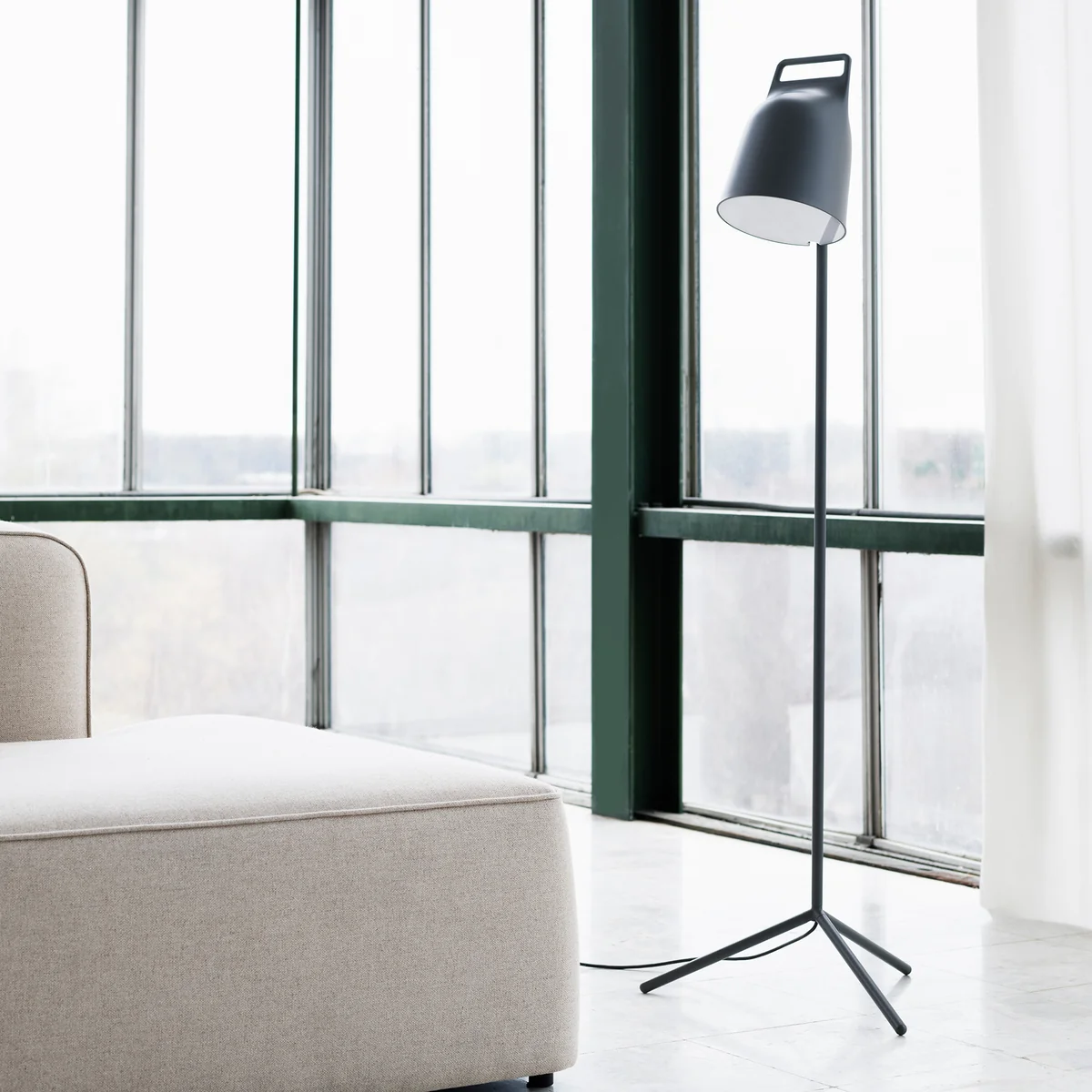 Die Stage LED-Stehleuchte von Normann Copenhagen vor einer Fensterfront