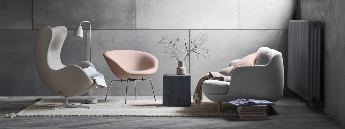 Das gemütliche Lune 2-Sitzer Sofa von Fritz Hansen mit dem passenden Pot Sessel in soften Grau und Rose-Tönen. Ein modernes Wohnzimmer-Ambiente vor grauer Wand.