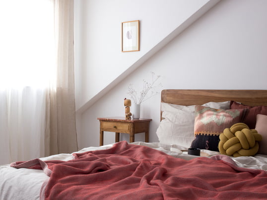 Pepper von heimatbaum.com zeigt uns, wie sie ihr Schlafzimmer mit der Ripple Decke von Muuto und dem Knot Kissen von Design House Stockholm in Rot- und Erdtönen gestaltet.