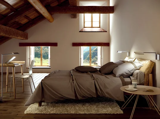 Von der Basis der Kant Leseleuchte von Estiluz geht ein Schwenkarm ab, an dem ein verstellbarer Lampenschirm befestigt ist. Die Leseleuchte eignet sich gut über dem Bett.