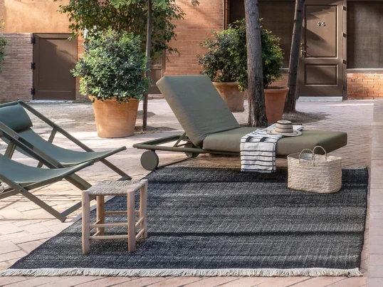 Der Tres Outdoor-Teppich von nanimarquina sorgt selbst im Pool-Bereich für eine unheimlich gemütliche Atmosphäre und gibt dem Außenbereich ein wohnliches Ambiente.