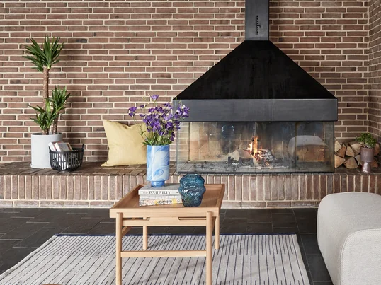 Ein cleaner und aufgeräumter Look, der nichts an Gemütlichkeit und Funktionalität einbüßt: dafür stehen die Wohnzimmermöbel des dänischen Studios Hübsch Interior, wie zum Beispiel mit dem Couchtisch mit Tablettablage.