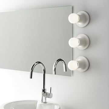 Punt Wand- und Deckenleuchte von Carpyen in weiß neben dem Spiegel