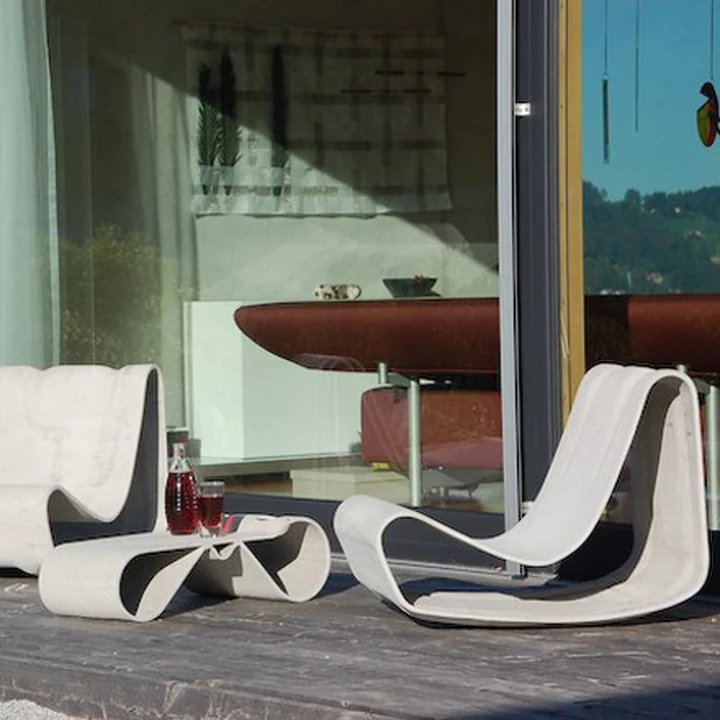 Der skulpturale Willy Guhl Loop Outdoor-Sessel und der Tisch von Eternit auf der Terrasse