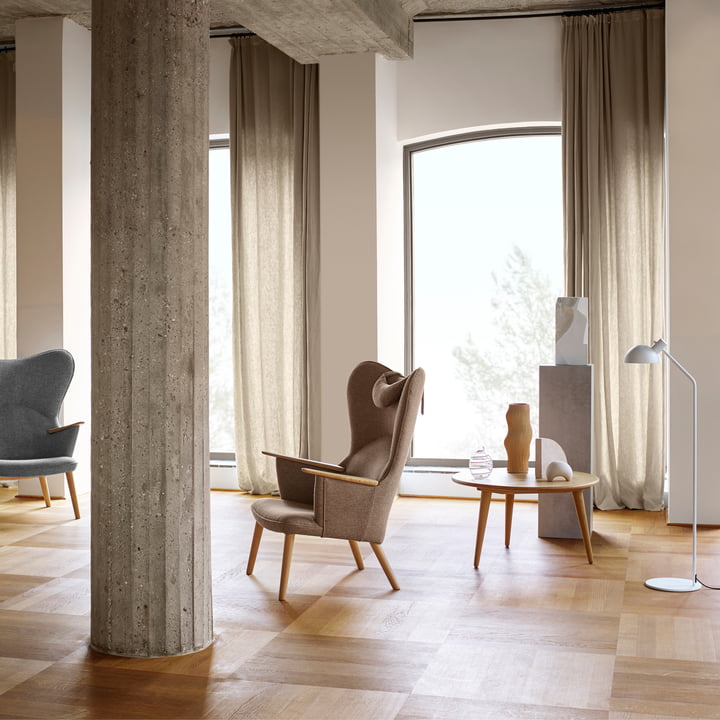 Der CH78 Mama Bear Lounge Chair von Carl Hansen in einem hellen Raum mit Steinsäulen und Holzboden