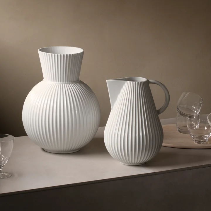 Die Lyngby Tura Jug Vase neben der Tura Vase, weiß von Lyngby Porcelæn auf dem Tisch