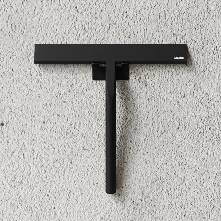 Der Duschabzieher von Nichba Design an einer Steinwand