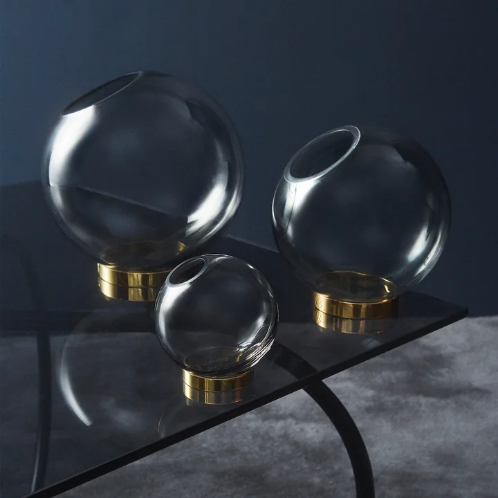 Die unterschiedlich großen Globe Vasen von AYTM auf einem Beistelltisch aus Glas