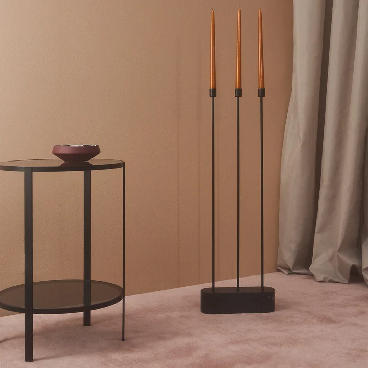 Der Grasil Kerzenhalter für den Boden von AYTM neben einem schwarzen Beistelltisch in einem Zimmer mit viel Rosa-Tönen