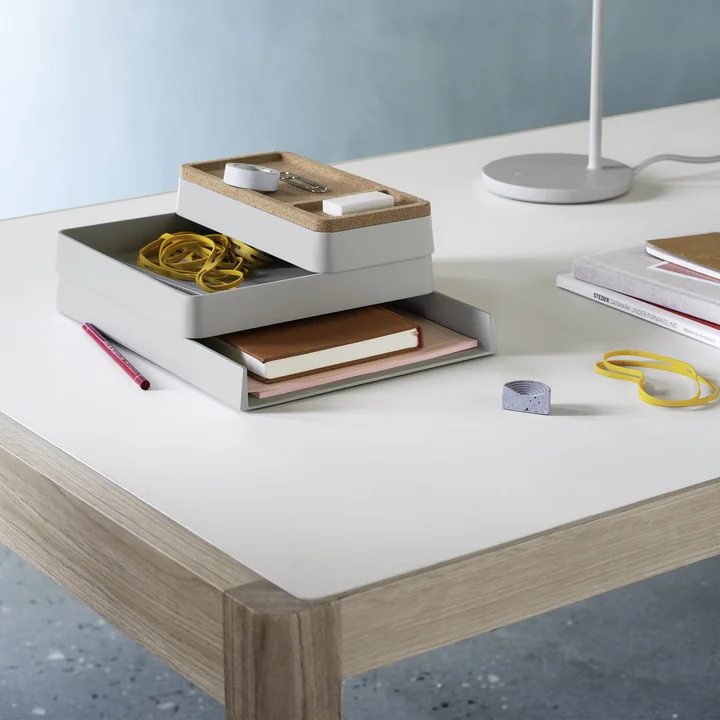 Der Arrange Desktop Organizer von Muuto auf einem weißen Schreibtisch neben einer Leuchte