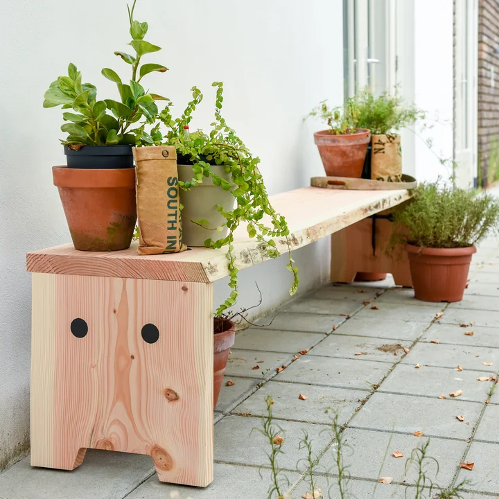 Die Forestry Bank von Weltevree im Freien mit vielen Pflanzen