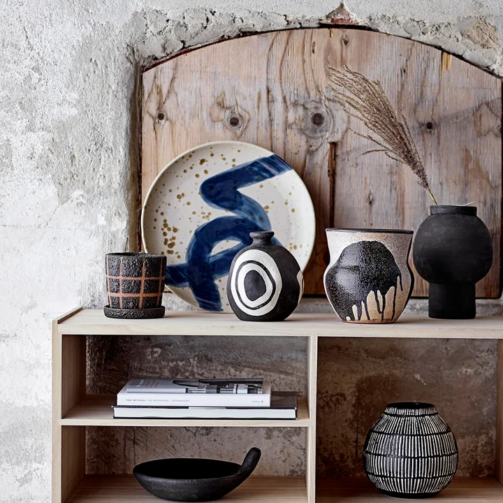 Der Oscar Wandteller von Bloomingville auf einem Holz-Sideboard neben Vasen und Deko-Objekten