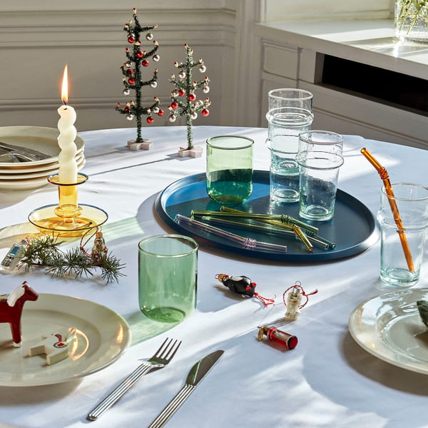 Trinkhalme, Trinkgläser und Kerzenhalter von Hay auf dem weihnachtlich gedeckten Tisch