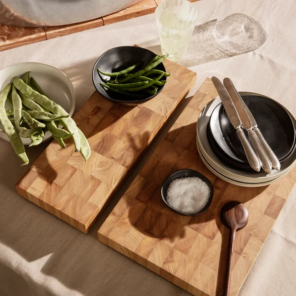 Das Chess Schneidebrett von Ferm Living in seinen verschiedenen Größen mit Geschirr und Besteck